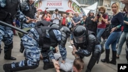 Полиция задерживает демонстранта во время протестов в Москве 12 июня 2017 года