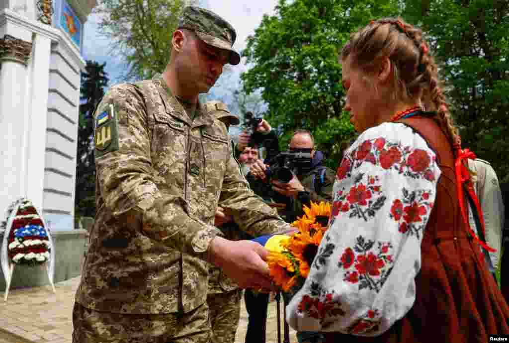 Член Почетного караула передает украинский государственный флаг Иванне Саниной