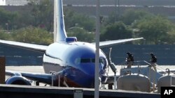 Саперы поднимаются на борт самолета авиакомпании Southwest Airlines в международном аэропорту Феникса.