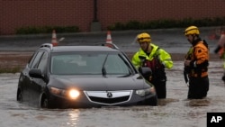 Пожарные помогают водителю машины на затопленной улице во время шторма, 21 ноября 2024 года, Санта-Роза, Калифорния